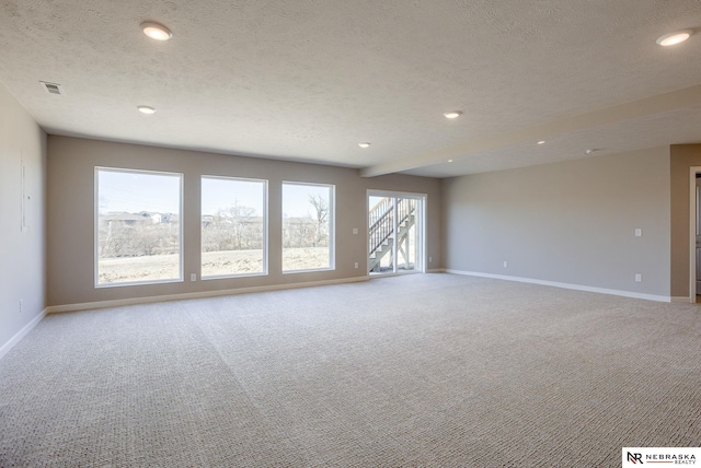 spare room featuring light carpet, visible vents, and baseboards