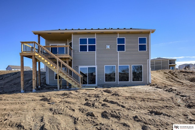 rear view of house featuring stairway and a wooden deck