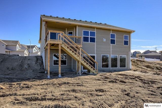 rear view of house featuring a deck and stairway