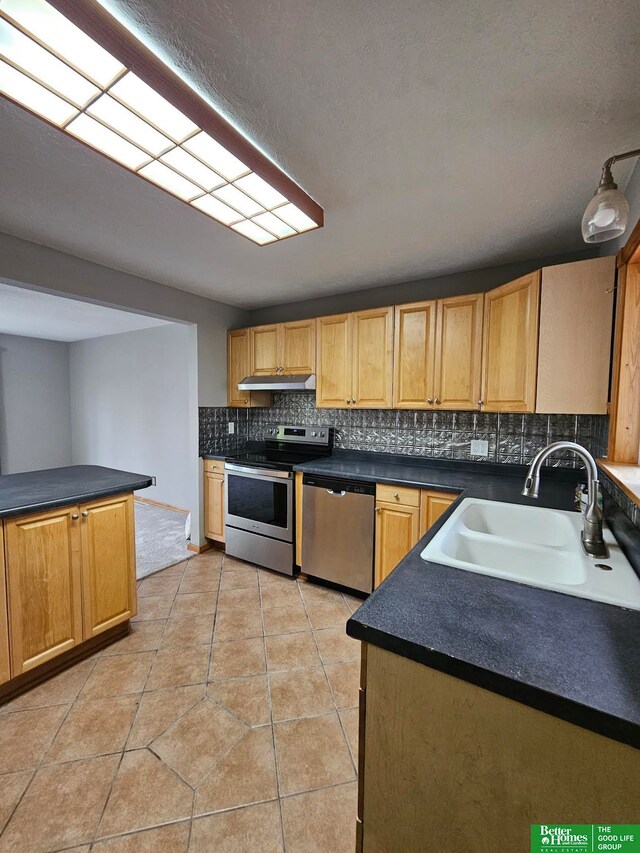 kitchen featuring decorative backsplash, appliances with stainless steel finishes, light tile patterned flooring, and sink