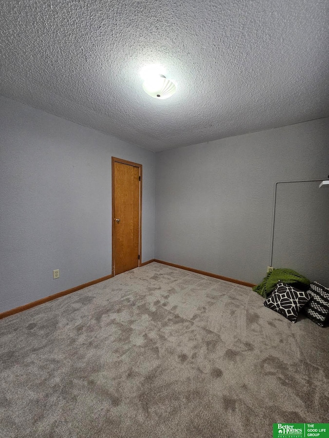 carpeted empty room featuring a textured ceiling