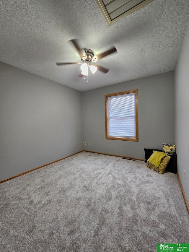 spare room featuring ceiling fan, carpet floors, and a textured ceiling