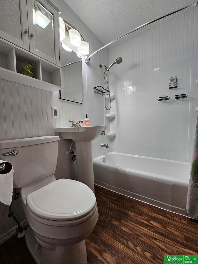 bathroom featuring hardwood / wood-style floors, toilet, shower / bathing tub combination, and a textured ceiling