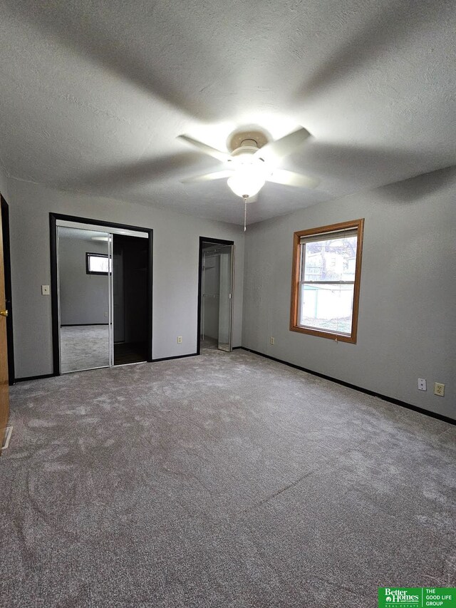 unfurnished bedroom with ceiling fan, carpet, and a textured ceiling