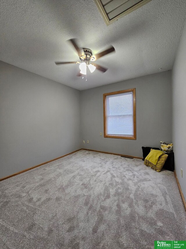 unfurnished room featuring ceiling fan, carpet, and a textured ceiling