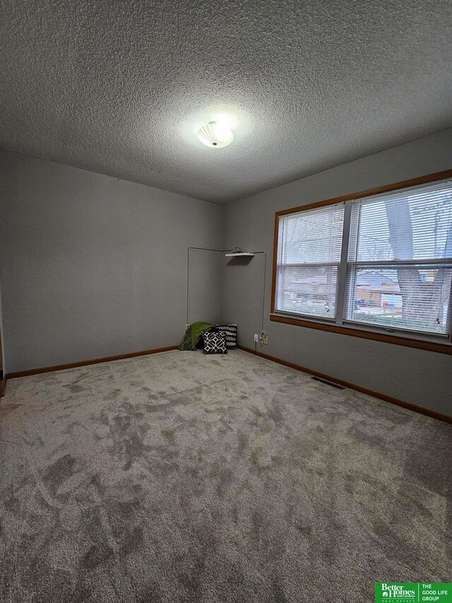 empty room featuring carpet flooring and a textured ceiling