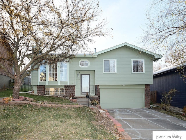 split foyer home with a garage and a front lawn