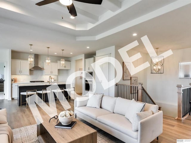 living room featuring ceiling fan with notable chandelier and light hardwood / wood-style floors