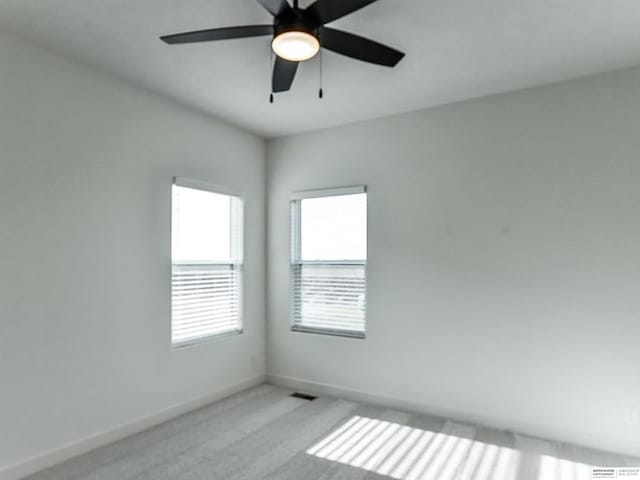 unfurnished room with ceiling fan and light colored carpet