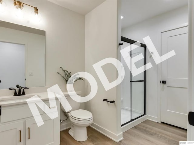 bathroom with hardwood / wood-style floors, vanity, toilet, and an enclosed shower