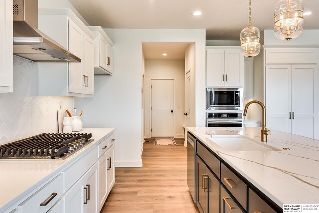 6614 S 200th Ave, Omaha, NE 68135 - kitchen featuring a chandelier, wall chimney range hood, tasteful backsplash, white cabinets, and light countertops