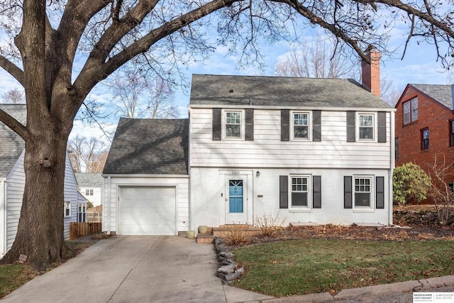 colonial inspired home featuring a garage and a front yard