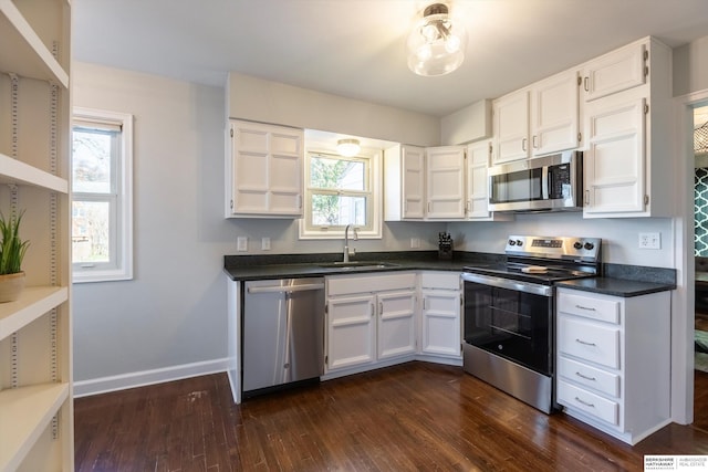 kitchen with dark hardwood / wood-style flooring, white cabinetry, sink, and appliances with stainless steel finishes