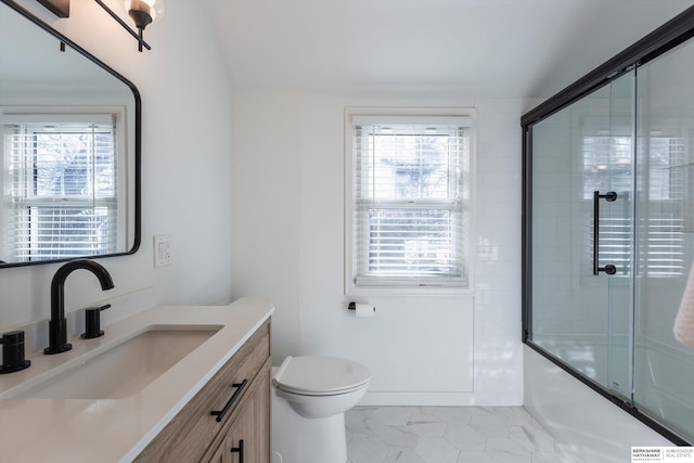 full bathroom with shower / bath combination with glass door, vanity, toilet, and a wealth of natural light