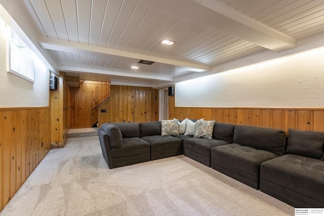 living room featuring beam ceiling, light carpet, and wooden walls