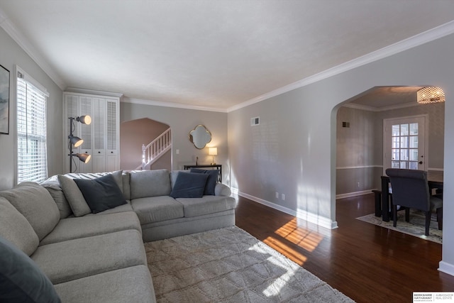 living room with a healthy amount of sunlight, dark wood-type flooring, and ornamental molding