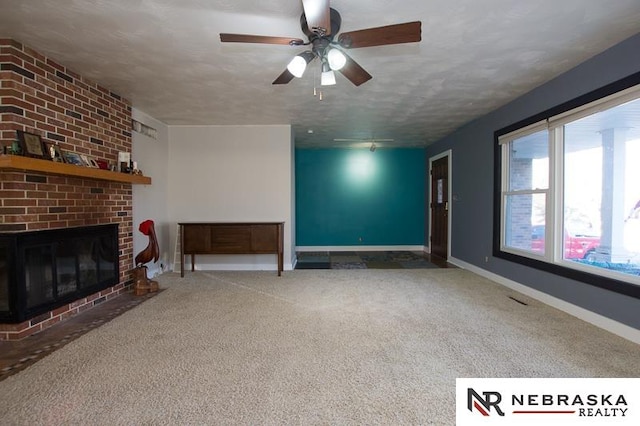 unfurnished living room with ceiling fan, a fireplace, carpet, and a textured ceiling