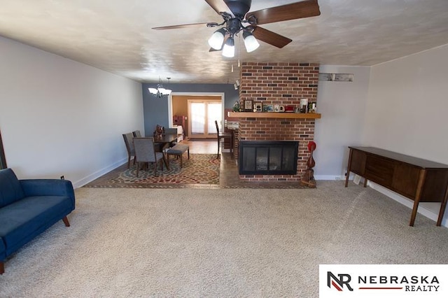 living room with carpet, ceiling fan with notable chandelier, and a brick fireplace