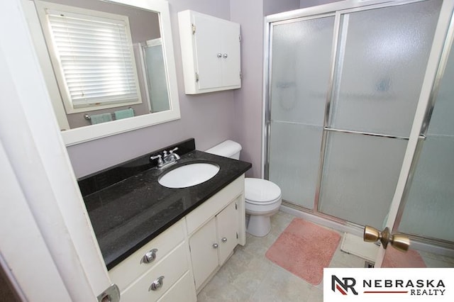 bathroom with a shower with door, vanity, and toilet