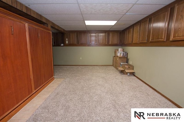 basement featuring light carpet and a drop ceiling