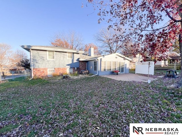 back of property featuring a patio and a yard