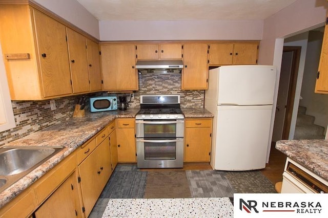 kitchen featuring range with two ovens, sink, white fridge, and backsplash