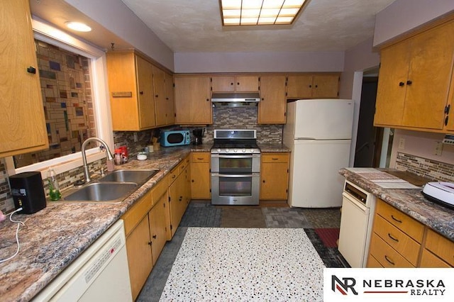 kitchen featuring white appliances, sink, and backsplash