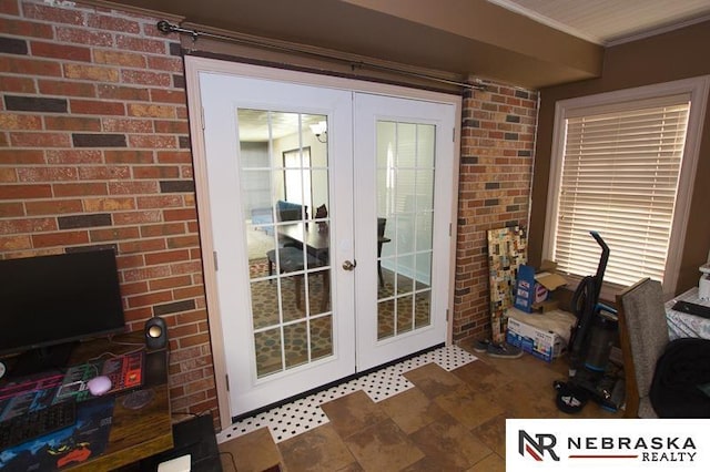 entryway featuring french doors, brick wall, and ornamental molding