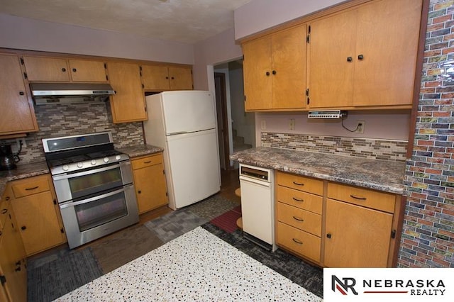 kitchen featuring double oven range, backsplash, and white refrigerator