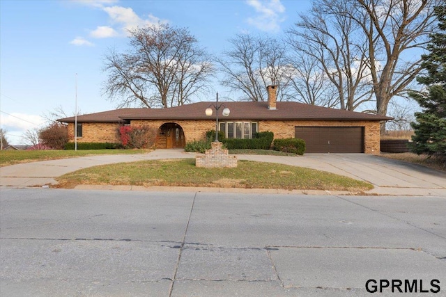 ranch-style home featuring a garage and a front lawn