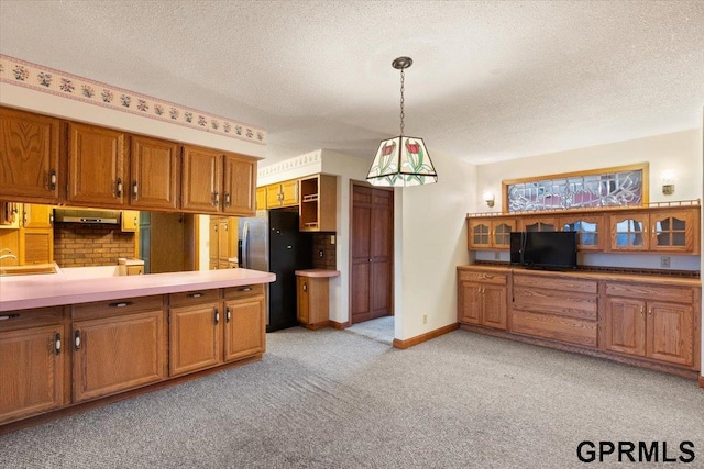 kitchen featuring pendant lighting, stainless steel fridge, light carpet, and a textured ceiling