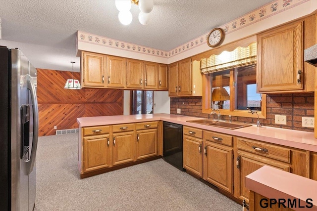 kitchen featuring dishwasher, kitchen peninsula, stainless steel fridge, wood walls, and decorative light fixtures