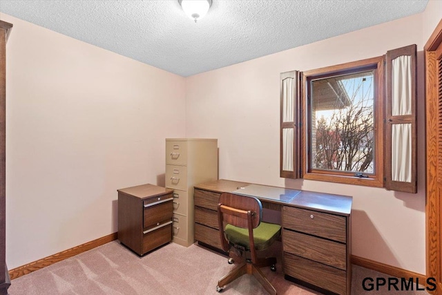 carpeted office featuring a textured ceiling