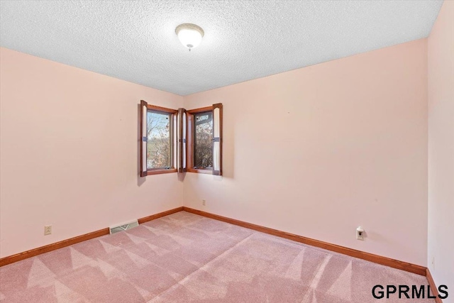 carpeted spare room with a textured ceiling