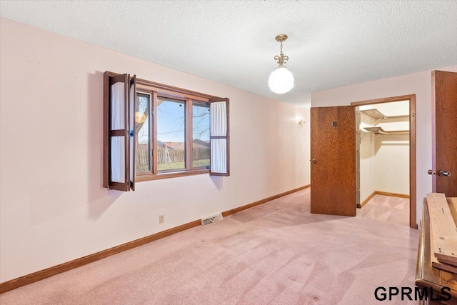 spare room featuring light carpet and a textured ceiling