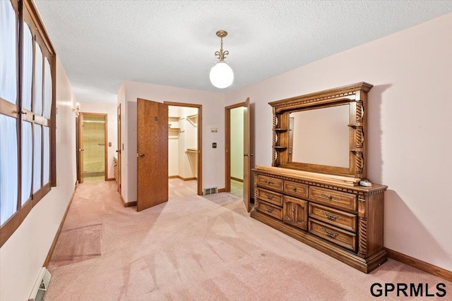 corridor with light carpet and a textured ceiling