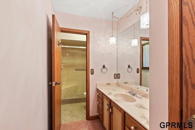 bathroom featuring a textured ceiling, vanity, an enclosed shower, and toilet