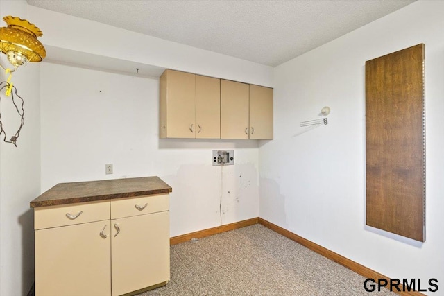 laundry room with light carpet, cabinets, a textured ceiling, and washer hookup