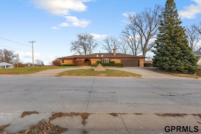 single story home with a front yard and a garage