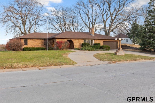 single story home featuring a garage and a front yard