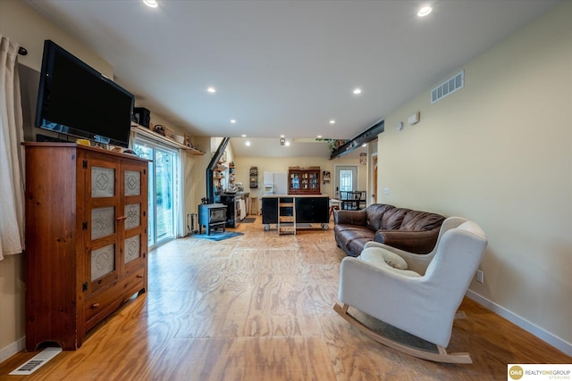 living room featuring a wood stove and light hardwood / wood-style flooring