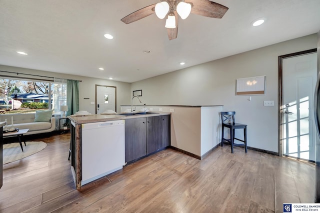 kitchen featuring white dishwasher, ceiling fan, sink, and hardwood / wood-style flooring