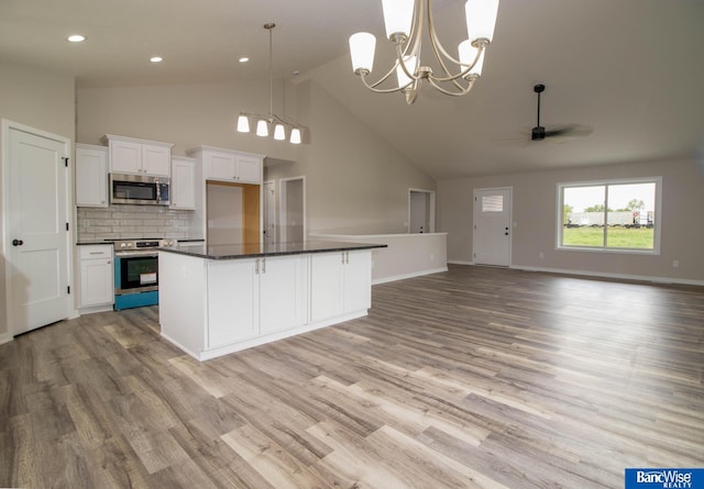 kitchen with white cabinetry, stainless steel appliances, decorative light fixtures, and a center island