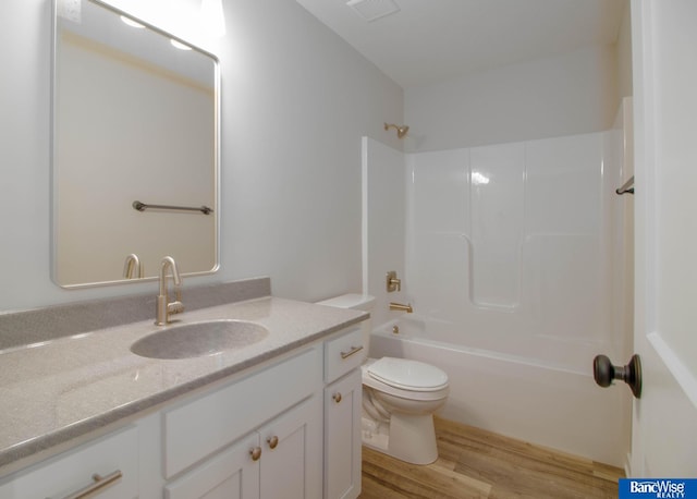 full bathroom with vanity, hardwood / wood-style flooring,  shower combination, and toilet