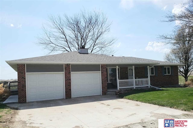 ranch-style house with covered porch, a garage, and a front lawn