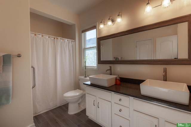 bathroom with hardwood / wood-style flooring, vanity, toilet, and walk in shower