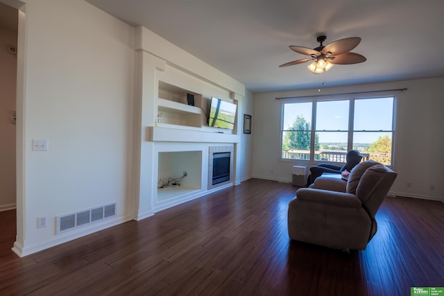 living room featuring built in features, ceiling fan, and dark wood-type flooring