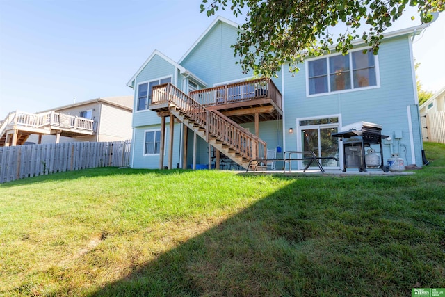 back of property with a deck, a yard, and a patio