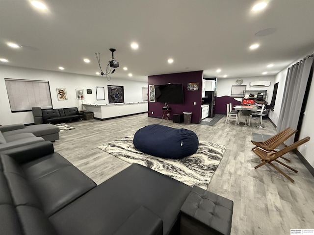 living room with a wall mounted air conditioner and light hardwood / wood-style flooring