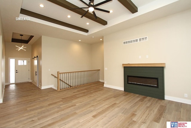 unfurnished living room featuring a high ceiling, light hardwood / wood-style flooring, ceiling fan, and beam ceiling